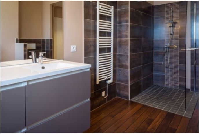 Badkamer met houten vloer en betegelde douche 